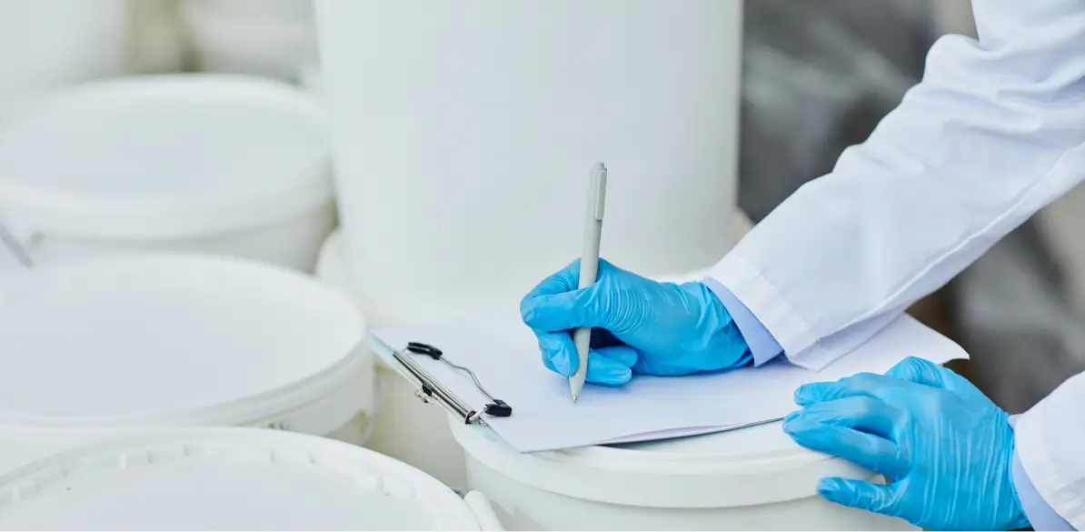 A technician checking a shipment of white drums