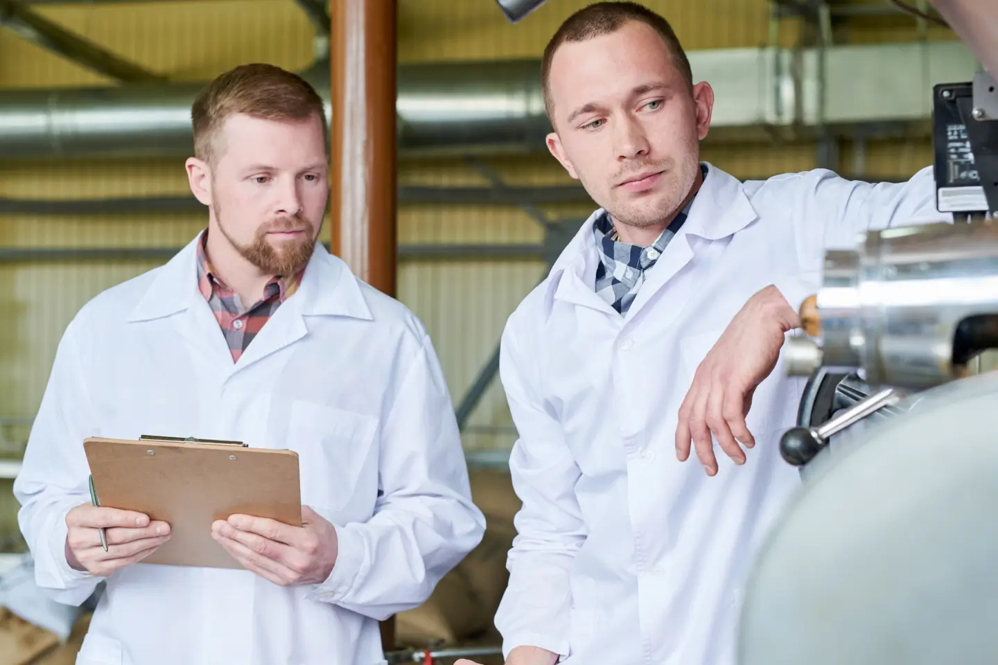 Dos técnicos inspeccionando el equipo de fabricación por encargo
