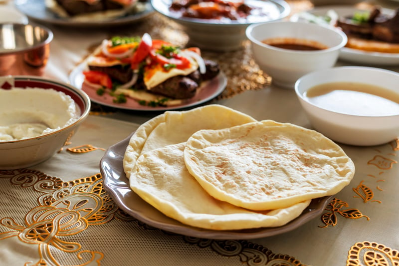  Cooked halal pita and sauces on a fancy tablecloth