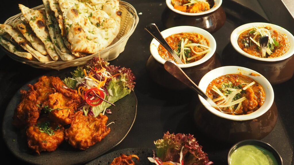 Bread, meat, and sauces served in ceramic bowls and plates