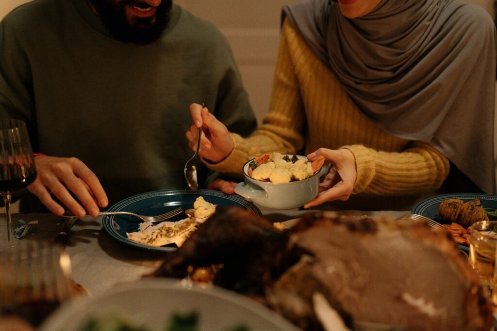 A woman sharing her food from a bowl with her friend